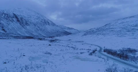 Dusk empty curvy winter road in icy snowy landscape in the mountains Stock Footage 149942762