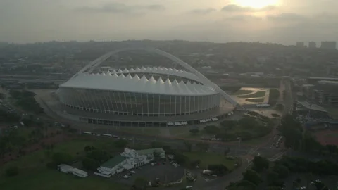 As dusk falls, a drone moves away from Moses Mabhida Stadium Video stock 239459865