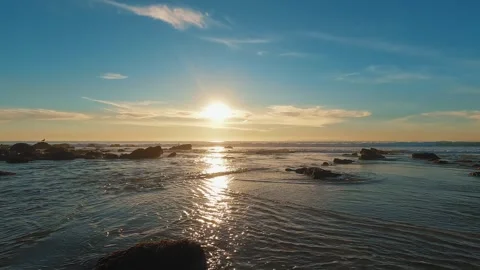 As dusk falls, a tranquil evening unfolds over a rugged shoreline, beneath an Stock Footage 277119513