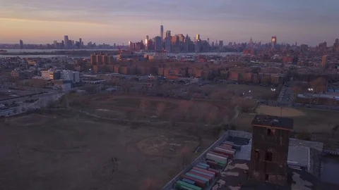 Dusk flying backwards over abandoned Red Hook grain terminal away from Manhattan Stock Footage