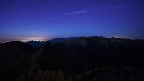 Dusk in the high mountain landscape. The mountain peaks are shrouded in darkness Stock Footage 202207992