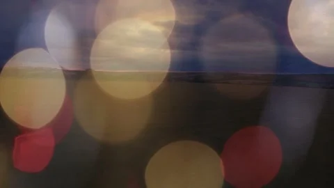 Dusk light shifting, bokeh circles drifting and fading, revealing thin horizon Stock Footage 333859676