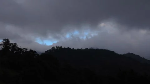 Dusk to night. Beautiful clouds flying fast over mountain tops. Video stock 278283148