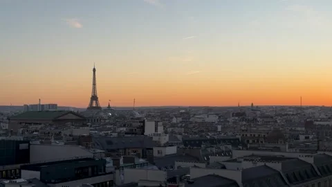 Dusk over Paris showcasing Eiffel Tower amid layered rooftops and haze Stock Footage 337184672