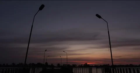Dusk over a river with lamp posts in a silhuette Stock Photos