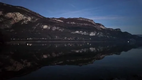 At dusk, reflections of the mountains fall into the lake 動画素材 263551853