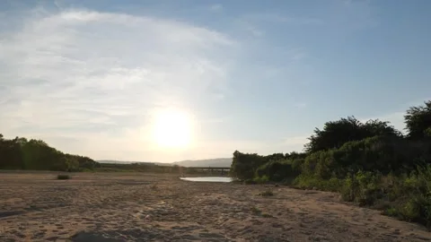Dusk, the river and an old bridge with the setting sun reflecting off it. Stock Footage 279122871