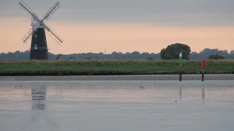 Dusk setting over the Mud flats and Windmill The Broads National Park Stock Footage 91796528