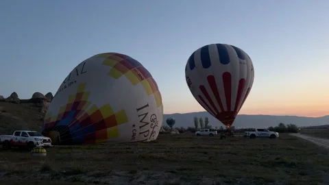 As dusk settles, two stunning hot air balloons prepare for launch Stock Footage 319095307