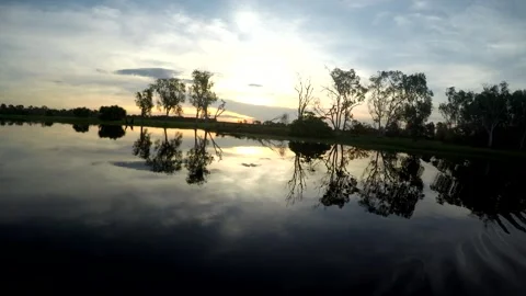 Dusk sky and trees reflected in still outback water Stock Footage 348007323