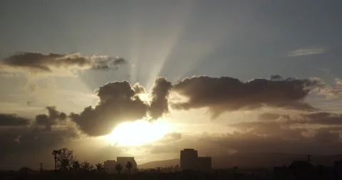 A dusk time lapse of a setting sun as it breaks through fast moving clouds 動画素材 238057853