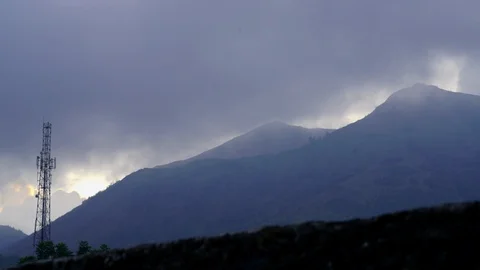 Dusk timelapse of mountain with clouds and a cell communication tower Stock Footage 124997193