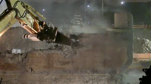 Dust and debris fly as two large hydraulic hammers work simultaneously to Stock Footage 185988587