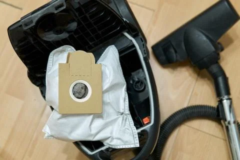 Dust bag full of garbage in the opened vacuum cleaner Photos