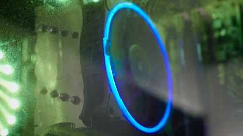 Dust covered cooling fan inside gaming PC with RGB illumination. Closeup through Stock Footage 339281439