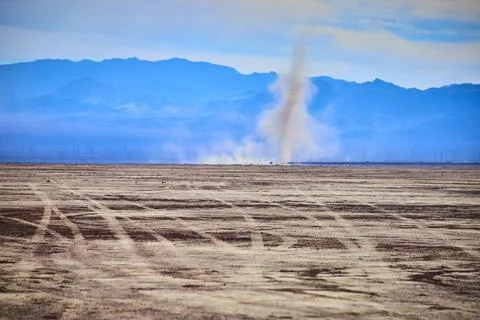 Dust Devil in Arid Desert with Mountain Backdrop Eye Level Perspective Stock Photos