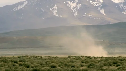 Dust Devil blowing across planes in Nevada in front of a mountain with Stock Footage 95750562