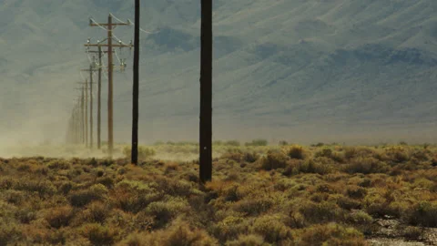 Dust devil roars through a row of power poles in the Mojave desert. Stock Footage 194401483