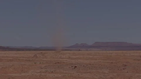 Dust devil whirlwind spinning across flat arid desert plain in Morocco Stock Footage 335962790