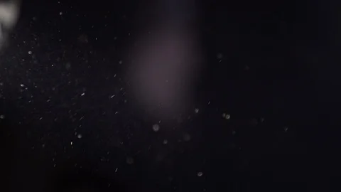 Dust flies through the air. Small particles move on a black background. Stock Footage 104702798
