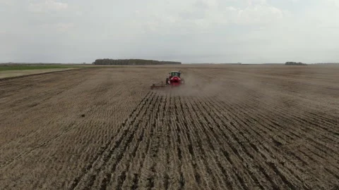 Dust flies from under the tractor plow Stock Footage 237061085