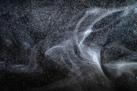 Dust particles cloud generating abstract shapes with black background and copy Foto stock