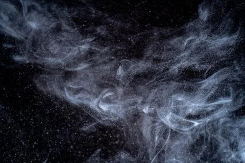 Dust particles cloud generating abstract shape on black background with copy Foto stock