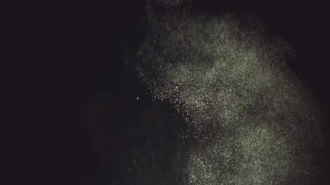 Dust particles swirl and explode in dark atmosphere, slow motion, close up. Stock Footage 337447819