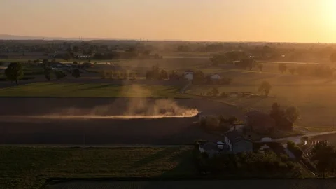 Dust plume rising from spring field tillage in Po Valley Italy during golden Stock Footage 336257325