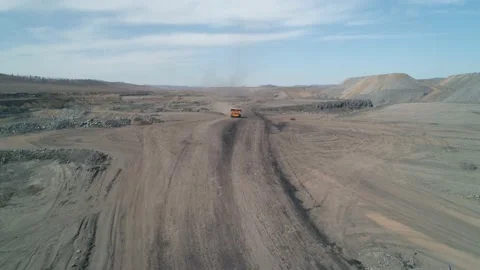 Dust rising behind fast-moving truck to be loaded into coal pit. Aerial view Stock Footage 203917506