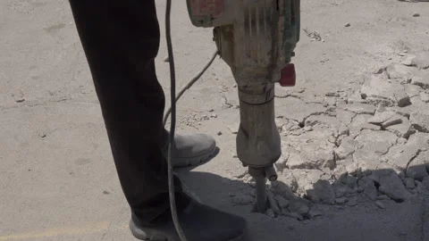 Dust rising as electric jackhammer breaks concrete pavement Stock Footage 343397485