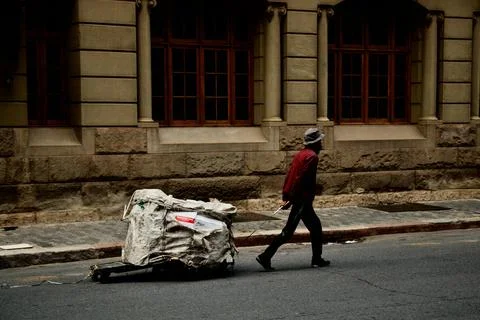 Dustbin Man Pulling Trolley with Trash in Street Stock Photos