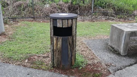 Dustbin near an empty stool in the park Stock Footage 170273362