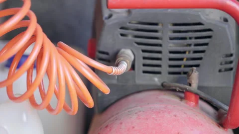 Dusted air compressor with spiral cable in workshop, machine with air pressure Stock Footage 269836764
