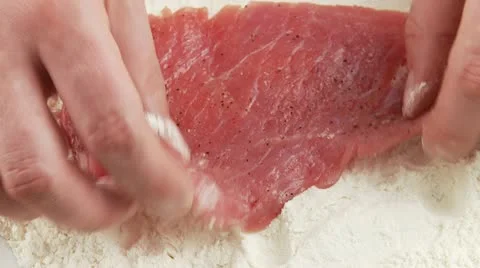 Dusting a seasoned escalope in flour Video stock 24636845