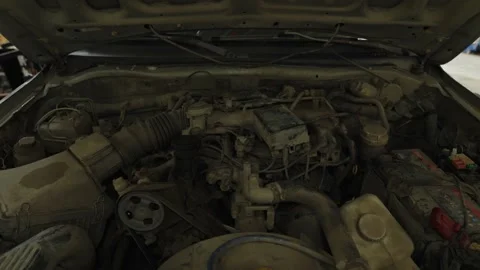 A dusty and dirty car engine sits inside an open bay Stock Footage 339684186