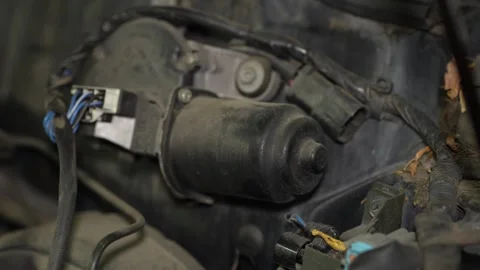 A dusty black electric windshield wiper motor assembly with electrical connec Stock Footage 345108677