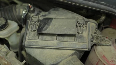 A dusty car air filter box with metal clips in the engine bay Stock Footage 340334729