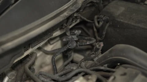 A dusty car engine compartment featuring a black plastic Stock Footage 342260212