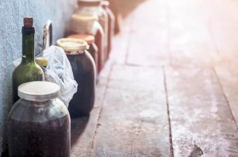 Dusty Jars of Jam with Plastic Caps, a Wine Bottle with Cork Covered with Spi Stock Photos