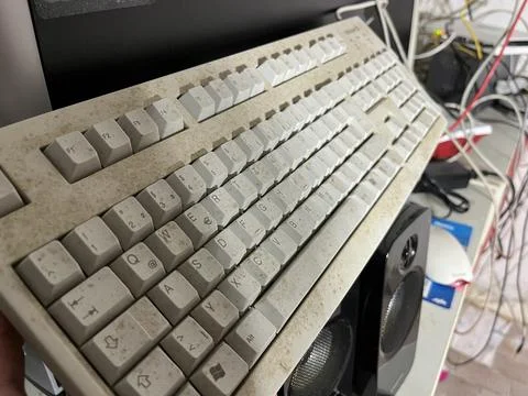Dusty Old Computer Keyboard in Cluttered Workspace Stock Photos