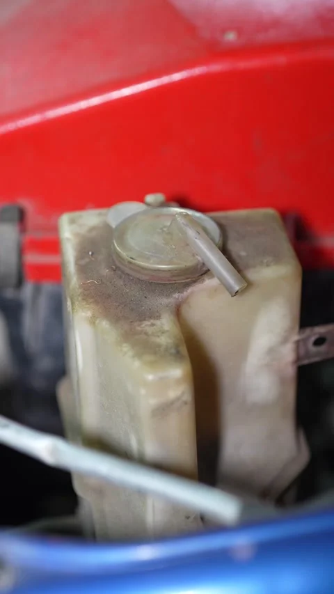 A dusty plastic car coolant overflow tank inside engine compartment. Stock Footage 345910003