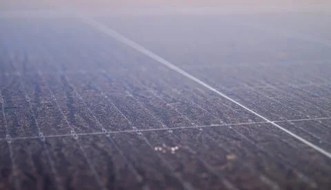 Dusty surface of a solar panel with grid lines, highlighting maintenance ch.. Stock Photos