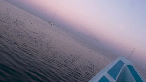 Dutch angle of the bow of a boat moving across the water during sunrise Stock Footage 57102709