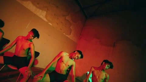 Dutch Angle Shot of Men Performing a Synchronized Chair Dance Stock Footage 234804533