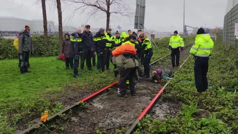 Dutch climate activists getting arrested for damaging the industrial rail track 動画素材 269830544