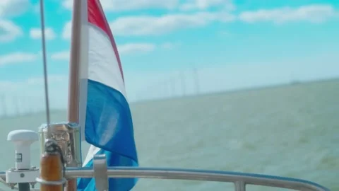 Dutch flag blowing int the wind on the back of a sail boat 스톡 동영상 207090552