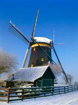 A Dutch mill in a winter landscape Stock Photos