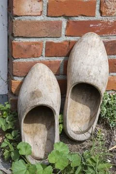 Dutch natural colored clogs at a back door of a Dutch house. Stock Photos