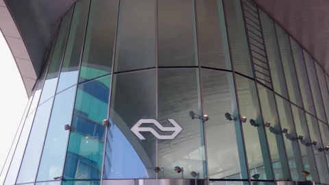 Dutch Railways (NS) logo displayed on the modern glass facade of a building in Stock Footage 338318282